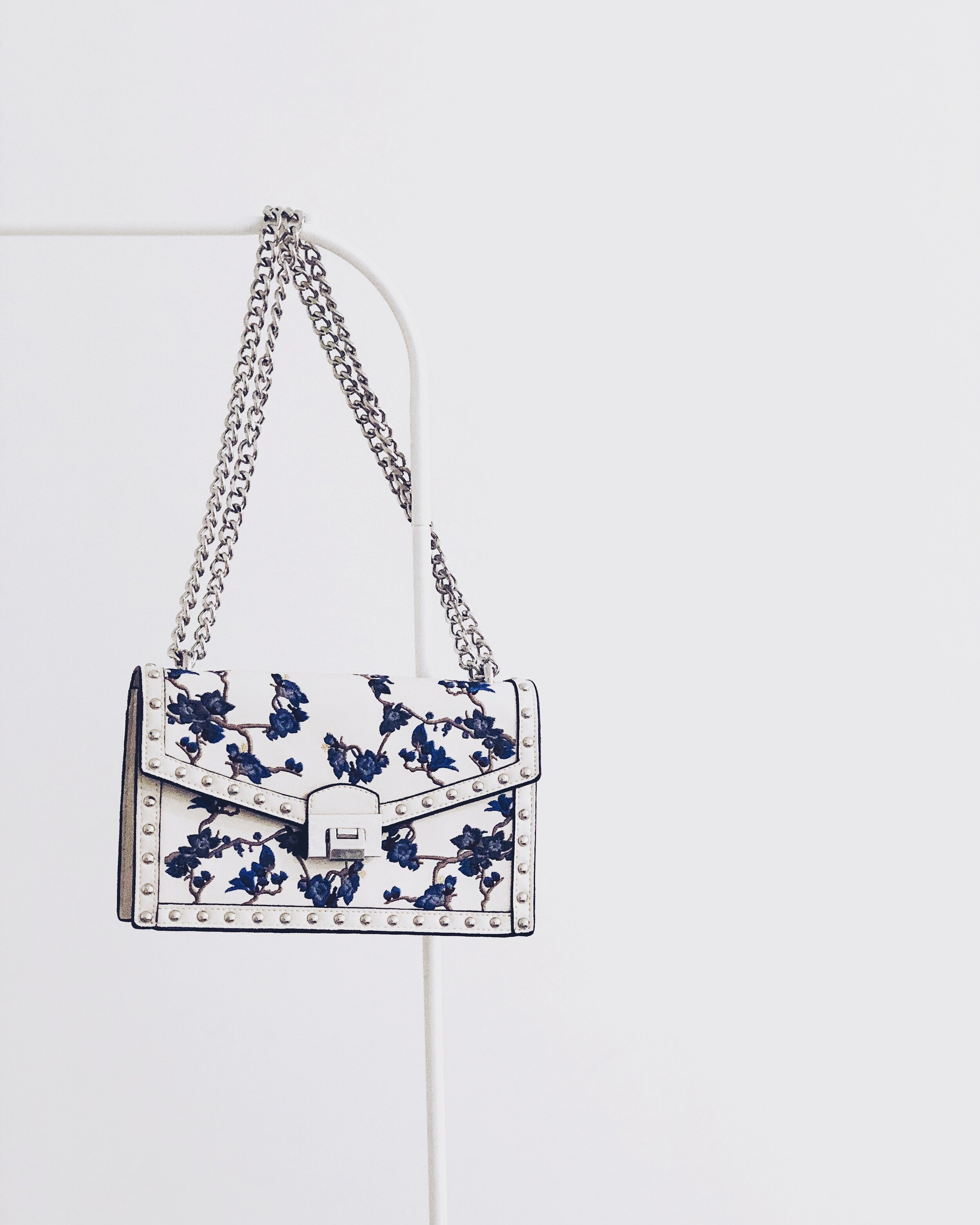 white-and-blue-floral-flap-sling-bag-hanging-on-white-steel-904350-2.jpg